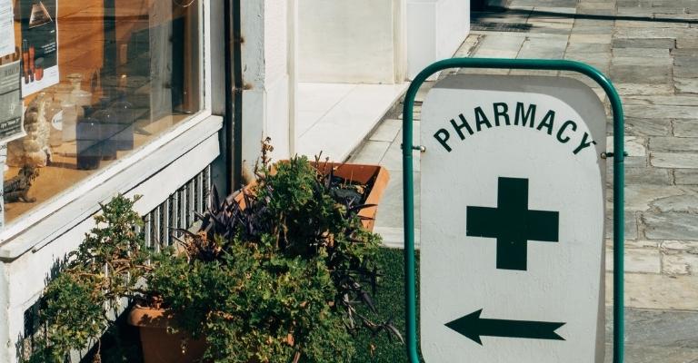 Pharmacy sign with green cross and arrow